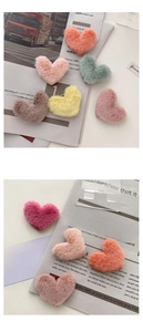 Detailed view of colorful plush heart hair clips in various macaron tones with soft texture