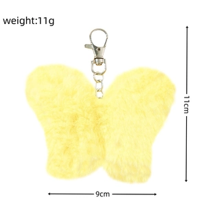 Detail showing plush yellow butterfly keychain with dimensions 11x9cm and lobster clasp