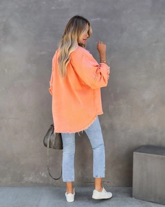Detail des Used-Saums und der Fransen an dieser übergroßen orangefarbenen Jeansjacke