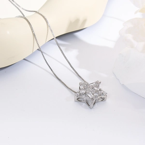 Macro shot of silver five-point star pendant with sparkling cubic zirconia on box chain