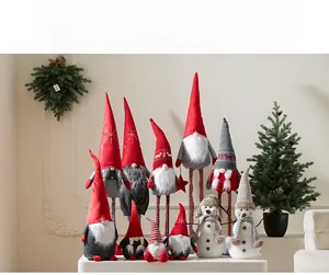 Detailed view of red plush Christmas gnomes and snowman figurines in a holiday setting