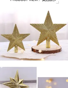Detail of golden glitter Christmas tree star toppers in two sizes with festive decor