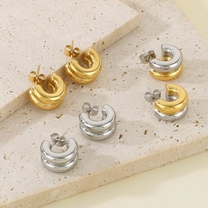 Minimalist C-shaped gold and silver mixed color hoop earrings on a stone base