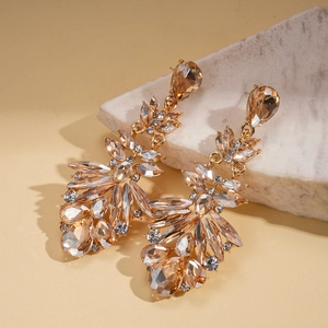 Detailed macro view of champagne crystal drop earrings with pear-cut stones and gold finish