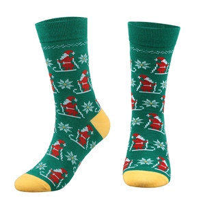 Detailed knit of green Christmas socks featuring ski Santa and yellow toe accents