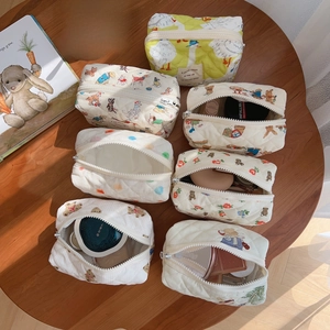 Quilted cotton cosmetic bags with cute bear and animal prints on a wooden table
