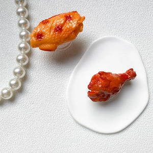 Macro view of realistic fried chicken wing and drumstick shaped phone grip stands
