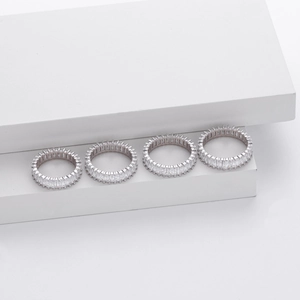 Close-up of four S925 sterling silver rings with rectangular zircon stones on white props