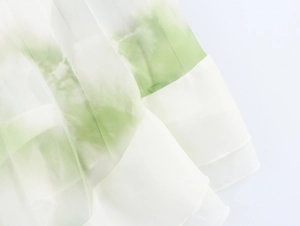 Detail of pleated floral chiffon fabric with white and green gradient printing
