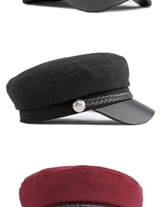 Detail of wool baker boy hats with leather brim and vintage shield buttons in black and red