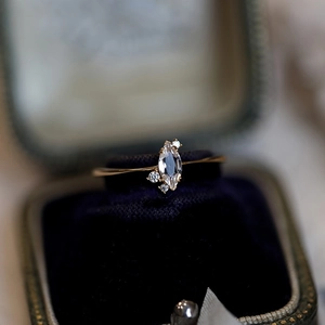 Macro detail of marquise-cut crystal ring with side stones in a vintage box