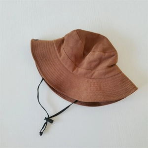 Close-up of tan outdoor sun hat with black adjustable drawstring and texture details