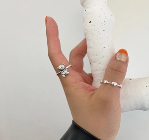 Close-up of minimalist S925 silver rings with cute bear and heart design for women