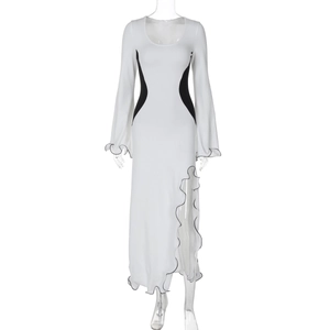 Détail d'une robe longue moulante contrastée noir et blanc avec fente et volant