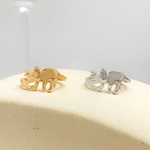 Detailed view of triceratops rings in gold and silver finish with open adjustable design