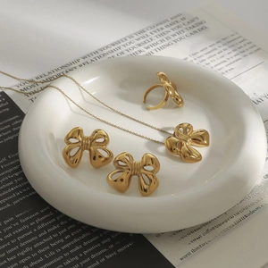 Luxury gold bow jewelry set featuring stainless steel necklace earrings and ring