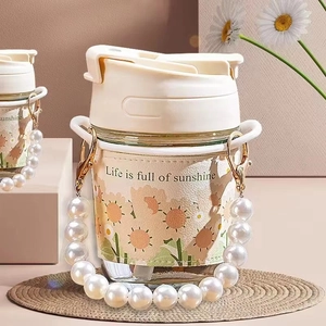 Detail of glass water bottle with sunflower sleeve, pearl strap and Life is sunshine quote