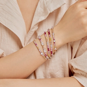 Close-up of stacked S925 sterling silver bracelets with colorful heart-shaped zircons