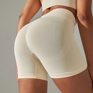 Detail view of seamless high-waisted beige yoga shorts with peach lift honeycomb texture