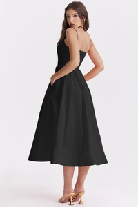 Detail of black midi sundress featuring side pockets and a flowing A-line silhouette
