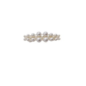 Elegant side hair clip featuring symmetrical white pearls on a gold-tone base frame