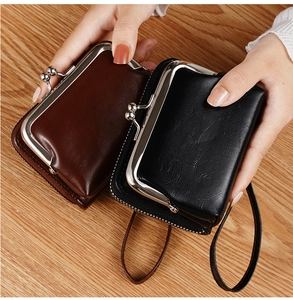 Close-up of vintage kiss-lock coin purses in black and brown PU leather with wrist straps