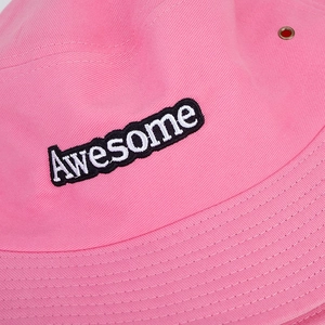 Détail du chapeau bob rose avec broderie Awesome et œillets d'aération métalliques sur le côté