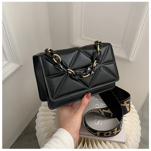 Detail of black geometric lattice shoulder bag with chain handle and patterned wide strap