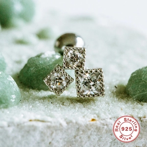 Macro shot of 925 sterling silver piercing stud with three square-cut clear zircons