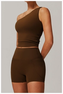 Detail view of high-waist yoga shorts with functional side pockets in chocolate brown color