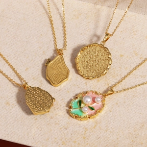 Detail view of gold necklaces showing enamel pendants and natural freshwater pearls