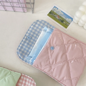 Internal view of pink quilted sanitary napkin pouch with blue plaid lining and snap button