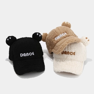 Detailed close-up of plush baseball caps with bear ears in black, khaki, and cream colors