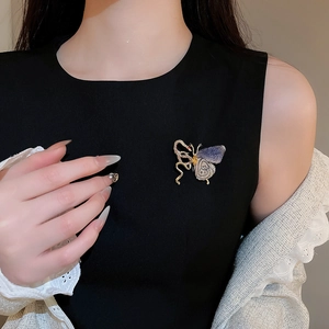 Detail of elegant knit butterfly brooch with rhinestones pinned on black suit lapel