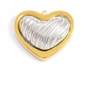 Macro view of a two-tone heart pendant with golden smooth frame and silver textured core