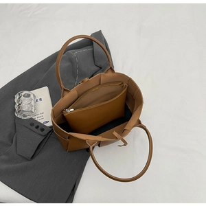 Detailed interior of brown woven tote bag showing the large capacity and matching pouch