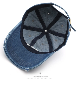 Detail of dark blue denim baseball cap interior showing distressed edges and adjustable strap