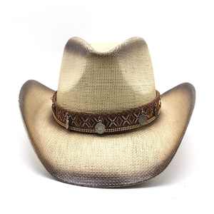 Detail of cream straw cowboy hat with ethnic band and hanging metal charms