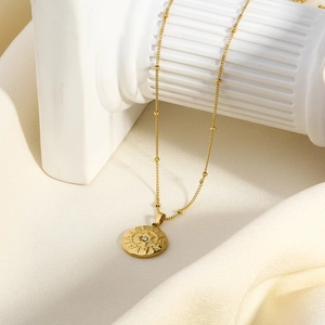 Detail of 18K gold-plated starburst medallion pendant on elegant satellite bead chain