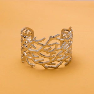 Detailed view of an elegant silver-toned open cuff bracelet with coral-like cutout texture