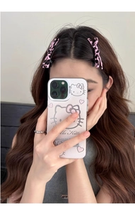 Detail shot of a trendy leopard print bow hair clip on model featuring pink aesthetic tones