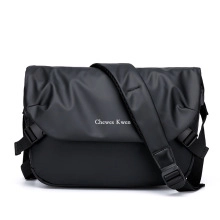 Gros plan de la besace à damier noir avec texture mate et bandoulière réglable