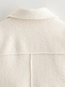 Close-up of the premium white woolen fabric texture and stitching on the short jacket