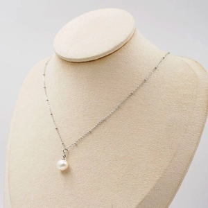 Elegant freshwater pearl pendant necklace on a silver chain displayed on a jewelry bust