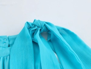 Close-up of blue chiffon halter neckline tie detail with soft fabric texture and ribbon