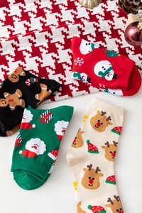 Flachbild von vier bunten Weihnachts-Baumwollsocken mit Schneemann- und Rentier-Motiven