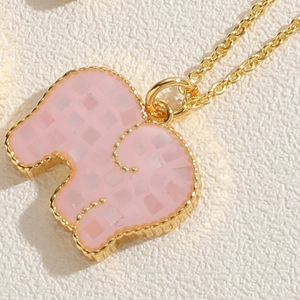 Detailed macro view of pink elephant pendant with 14K gold plating and shell texture