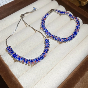 Gros plan de bracelets en zircon avec motifs mosaïques bleu et rouge dans un écrin