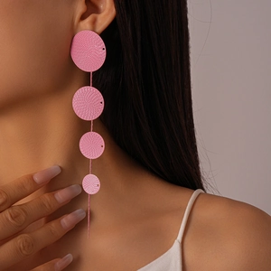 Detail of pink tiered circular drop earrings featuring spiral texture on a female model
