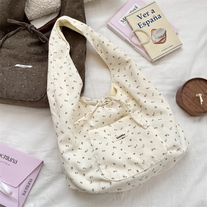 Flat lay of corduroy shoulder bags with drawstring closure and floral pattern lining